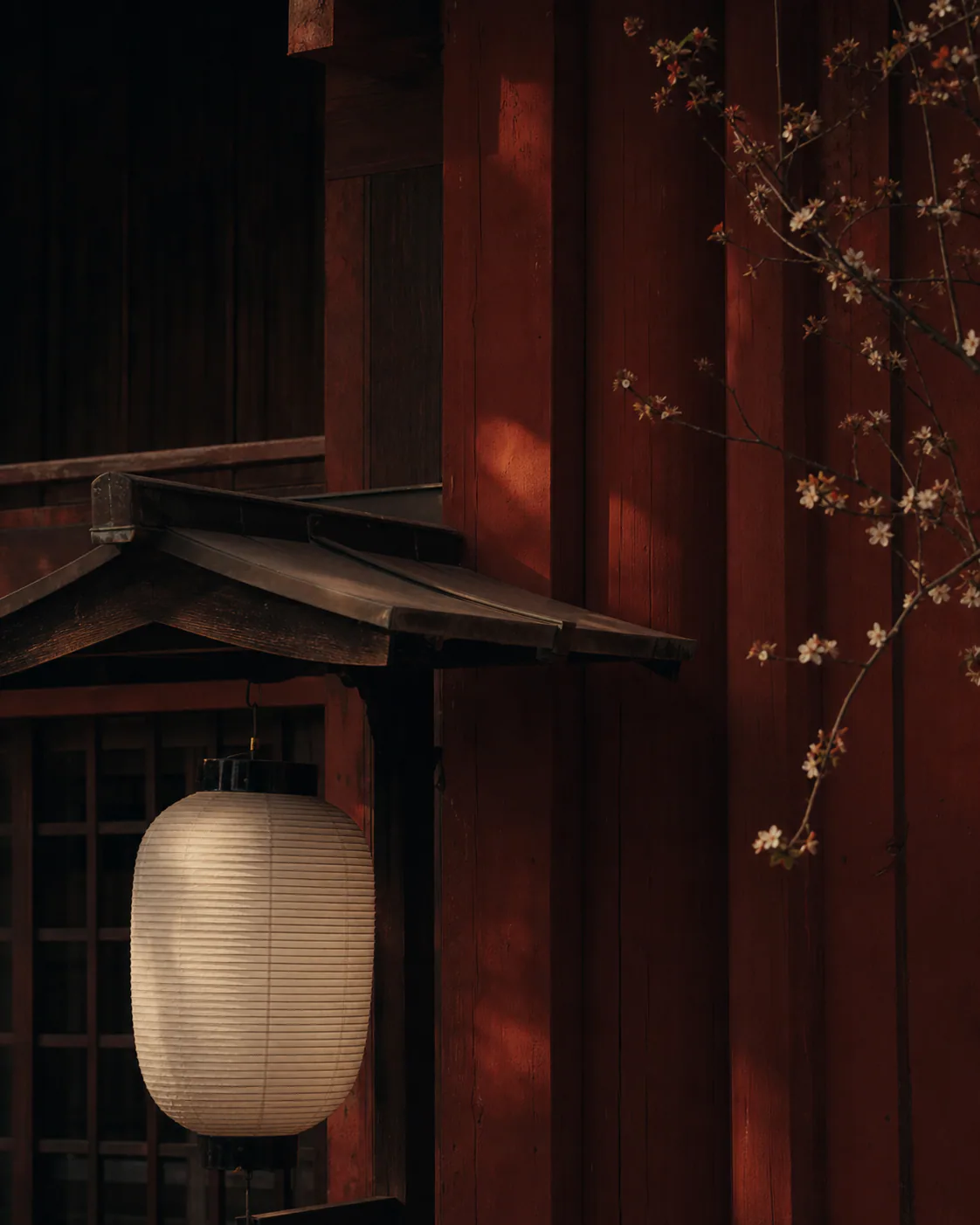A white lantern before vermilion timber.